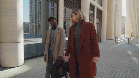 Two-Stylish-Diverse-Businessmen-Walking-Outdoors-and-Talking